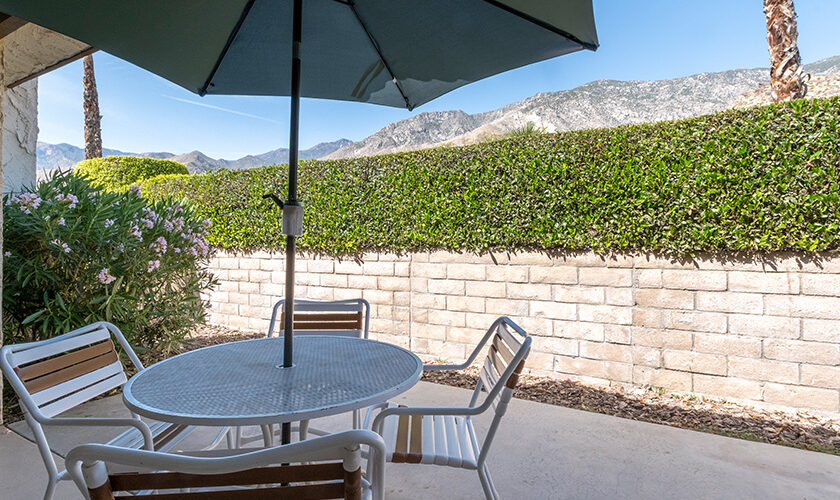 Patio with glass table, umbrella and four chairs